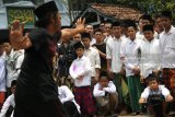 Sejumlah santri mengamati peragaan jurus oleh pendekar silat saat pertunjukan Pencak Dor (tarung bebas diiringi sholawat) di area pondok pesantren Lirboyo, Kota Kediri, Jawa Timur, Kamis (1/3). Sejumlah perguruan silat yang tergabung dalam paguyuban Pencak Dor merapatkan barisan dan sepakat melindungi ulama dari gangguan keamanan guna menjaga suasana kondusif menjelang Pilkada. Antara Jatim/Prasetia Fauzani/zk/18