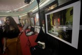 Pengunjung melihat foto karya Anton Gautama saat acara pameran, diskusi dan peluncuran buku foto 