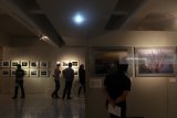 Pengunjung mengamati karya fotografi yang dipamerkan pada pameran foto Tohoku di Orasis Art Gallery, Surabaya, Jawa Timur, Senin (19/3). Pameran foto Tohoku Through The Eyes of Japanese Photographers tersebut menampilkan puluhan foto keindahan alam, masyarakat, serta relik peninggalan era Jomon di Tohoku yang diambil oleh 10 fotografer Jepang dalam rentang tahun 1940 hingga 2010. Antara Jatim/Zabur Karuru/18