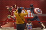 Pengunjung mengambil gambar action figur superhero marvel Iron Man dan Captain America yang dipamerkan pada Experience Marvel Universe Exhibition di Surabaya, Jawa Timur, Rabu (28/3). Pameran tersebut dalam rangka menyambut film Avengers 'Infinity War' di Indonesia pada 25 April. Antara Jatim/Zabur Karuru/zk/18