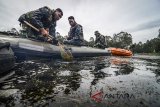 Anggota TNI mengambil sampah saat melakukan patroli bersih di Kawasan Hulu Sungai Citarum, Situ Cisanti, Kabupaten Bandung, Jawa Barat, Selasa (13/3). Dalam enam bulan ke depan, kegiatan tersebut difokuskan pada revitalisasi dan rehabilitasi kawasan hulu yang merupakan rangkaian dari program Citarum Harum. ANTARA JABAR/Raisan Al Farisi/agr/18.
