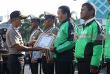 Kapolrestabes Surabaya Komisaris Besar (Kombes) Pol Rudi Setiawan (kiri) memberikan piagam penghargaan kepada pengemudi ojek daring bernama Dwi Agus Indarto (33) saat Pemberian Penghargaan Pengemudi Ojek Peduli Kamtibmas di Polrestabes Surabaya, Jawa Timur, Kamis (29/3). Polrestabes Surabaya memberi penghargaan kepada tiga pengemudi ojek daring yaitu Dwi Agus Indarto (33), Mahardika Nugraha Hariyanto (28) dan Soeroso (51) bersama dua polisi dari Polsek Gubeng atas upaya menggagalkan penjambretan yang dilakukan AH (30) serta AHD (28) terhadap korban bernama Umi Farida (22) di Jalan Jojoran, Surabaya, pada Selasa (27/3/2018) lalu. Antara Jatim/Didik Suhartono/zk/18