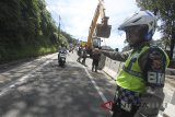 Polisi mengatur lalu lintas saat penutupan jalur Puncak di Ciloto, Cianjur, Jawa Barat, Kamis (29/3). Ruas jalan jalur Puncak Gunung Mas, Bogor, hingga Ciloto, Cianjur, kembali ditutup karena longsornya bahu jalan. Jalan hanya boleh dilalui sepeda motor hingga waktu yang belum bisa ditentukan, menunggu kajian teknis Kementerian Pekerjaan Umum dan Perumahan Rakyat (PUPR) dan pihak terkait. ANTARA JABAR/Yulius Satria Wijaya/agr/18.