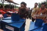 Meneteri BUMN Rini Soemarno (kiri) bersama Direktur Utama BNI Achmad Baiquni (kedua kanan) dan Dirut PTPN X Dwi Satriyo Annurogo (kanan) meninjau  perlengkapan pendukung produksi pertanian yang akan digunakan pada lahan Perhutanan Sosial di Tuban, Jawa Timur, Jumat (9/3). Selain itu, BNI juga menyalurkan Kredit Usaha Rakyat (KUR) kepada petani penggarap lahan hutan melalui Program Perhutanan Sosial yang digagas oleh Pemerintah. Antara Jatim/Zabur Karuru/zk/18