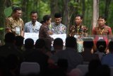 Meneteri BUMN Rini Soemarno (ketiga kiri) bersama Direktur Utama BNI Achmad Baiquni (kiri) memberikan secara simbolis penyaluran KUR kepada petani di Tuban, Jawa Timur, Jumat (9/3). Penyaluran KUR, Kartu Tani, dan CSR BNI di Tuban merupakan bagian dari acara penyerahan Program Perhutanan Sosial tahap ke-2 tahun 2018 di  Jawa Timur. Antara Jatim/Zabur Karuru/zk/18