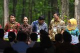 Menteri BUMN Rini Soemarno (kedua kiri) bersama Direktur Utama BNI Achmad Baiquni (kedua kanan) memberikan secara simbolis penyaluran KUR kepada petani di Tuban, Jawa Timur, Jumat (9/3). Penyaluran KUR, Kartu Tani, dan CSR BNI di Tuban merupakan bagian dari acara penyerahan Program Perhutanan Sosial tahap ke-2 tahun 2018 di  Jawa Timur. Antara Jatim/Zabur Karuru/zk/18