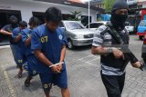 Petugas menggelandang tersangka saat ungkap kasus peredaran narkotika di Kantor Badan Narkotika Nasional Provinsi (BNNP) Jawa Timur, Selasa, Jawa Timur, Rabu (28/3). Tiga tersangka berinisial NR (33), SK (34) dan DD (32) yang mendapat perintah dari seseorang berada di Lapas Grobogan Bali ditangkap BNNP Jatim atas kasus dugaan mengedarkan Ganja dan sejumlah barang bukti diamankan diantaranya narkotika jenis Ganja dengan berat sekitar 19,8 kilogram. Antara jatim/Didik Suhartono/zk/18