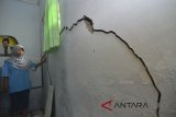 Warga menunjukan dinding rumah retak akibat pergerakan tanah di Desa Payung Agung, Kabupaten Ciamis, Jawa Barat, Senin (5/3). Sebanyak 65 rumah warga retak akibat pergerakan tanah dan sebanyak 191 jiwa warga harus mengungsi di Aula Bale Desa terdekat. ANTARA JABAR/Adeng Bustomi/agr/18