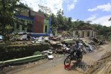 Warga melintas di samping rumah yang rusak akibat pergerakan tanah di desa Randusari, Cibeureum, Kuningan, Jawa Barat, Selasa (27/2). Pergerakan tanah tersebut menyebabkan sedikitnya 40 rumah warga rusak dan warga terpaksa diungsikan ke daerah yang lebih aman. ANTARA JABAR/Dedhez Anggara/agr/18.