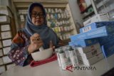 Seorang asisten apoteker meracik obat di Apotek Arcamanik, Bandung, Jawa Barat, Rabu (21/3). Gabungan pengusaha farmasi Indonesia menyatakan pada 2017 industri farmasi, obat kimia dan tradisional tumbuh 6,85 persen, serta investasi di industri tersebut melonjak hingga Rp 5,8 triliun dibandingkan tahun sebelumnya. ANTARA JABAR/Raisan Al Farisi/agr/18