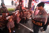 Polisi menjelaskan kepada murid-murid TK dan SD Kemala Bhayangkari tentang peralatannya saat acara Polisi Sahabat Anak di Surabaya, Jawa Timur, Kamis (15/3). Kegiatan yang diisi dengan edukasi dalam berlalu-lintas serta pengenalan fungsi dan tugas kepolisian tersebut guna menanamkan kecintaan anak kepada polisi. Antara Jatim/Moch Asim/zk/18