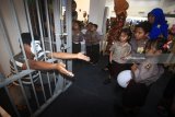 Murid-murid TK dan SD Kemala Bhayangkari menyaksikan simulasi kondisi di dalam tahanan saat acara Polisi Sahabat Anak di Surabaya, Jawa Timur, Kamis (15/3). Kegiatan yang diisi dengan edukasi dalam berlalu-lintas serta pengenalan fungsi dan tugas kepolisian tersebut guna menanamkan kecintaan anak kepada polisi. Antara Jatim/Moch Asim/zk/18