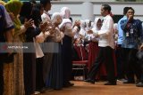 Presiden Joko Widodo (kedua kanan) menyalami siswa saat menghadiri penyerahan Kartu Indonesia Pintar dan Program Keluarga Harapan di Gor Tri Dharma, Gresik, Jawa Timur, Kamis (8/3). Penerima Kartu Indonesia Pintar di wilayah Jawa Timur sebanyak 2,19 juta siswa dan penerima Program Keluarga Harapan di Jawa Timur sebanyak 1,76 juta keluarga. Antara Jatim/Zabur Karuru/18