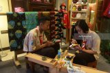 Pelajar melukis topeng karakter tokoh Panji Asmorobangun dan Dewi Sekartaji di Hotel Swissbellinn, Malang, Jawa Timur, Sabtu (10/3). Kegiatan tersebut merupakan upaya dari para pelajar mempromosikan kesenian tari topeng Panji yang lahir pada masa kerajaan Majapahit kepada pengunjung. Antara jatim/Ari Bowo Sucipto/zk/18.