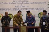 Ketua Umum PP Muhammadiyah Haedar Nasir (kedua kanan) bertukar naskah dengan Direktur Umum BPJS Kesehatan Fachmi Idris (kedua kiri) ketika penandatanganan MoU disela-sela Rapat Kerja Nasional Majelis Pembina Kesehatan Umum (MPKU) Pimpinan Pusat Muhammadiyah di Surabaya, Jawa Timur, Rabu (7/3). Rakernas MPKU PP Muhammadiyah  upaya untuk menata ulang dan menyusun dakwah bil hal Muhamadiyah di bidang layanan kesehatan. Antara Jatim/M Risyal Hidayat/zk/18