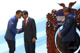 Presiden Joko Widodo (kedua kiri) berjabat tangan dengan Ketua Kogasma Partai Demokrat Agus Harimurti Yudhoyono (kiri) disaksikan oleh Ketua Umum Partai Demokrat Susilo Bambang Yudhoyono (kanan) saat membuka Rapat Pimpinan Nasional  (Rapimnas) Partai Demokrat 2018 di Sentul International Convention Center (SICC), Bogor, Jawa Barat, Sabtu (10/3). Rapimnas tersebut diagendakan membahas kesiapan Partai Demokrat delam menghadapi Pemilihan Umum 2019 mendatang. ANTARA JABAR/Yulius Satria Wijaya/agr/18. 
