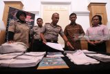 Kapolrestabes Surabaya Komisaris Besar (Kombes) Pol Rudi Setiawan (tengah) menunjukkan barang bukti sejumlah amplop berisi Kartu Indonesia Pintar di Polrestabes Surabaya, Jawa Timur, Jumat (23/3). Polrestabes Surabaya melakukan penyelidikan secara intensif terhadap 643 lembar Kartu Indonesia Pintar yang ditemukan di salah satu tempat usaha 'laundry' di Jangkungan Sukolilo terbengkalai dan diduga tidak terdistribusikan kepada penerimanya.  Sejumlah saksi termasuk kurir berinisial AZHR yang bertugas mengirim kartu KIP itu turut diminta keterangan. Antara Jatim/Didik Suhartono/zk/18