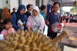 Sejumlah penumpang kereta api menikmati durian di Stasiun Jember, Jawa Timur, Jumat (30/3). PT KAI Daop 9 Jember menggelar Festival Durian untuk mendukung produksi buah lokal di wilayah setempat, sehingga pengunjung yang dapat menunjukkan boarding pass KA H-7/H+7 keberangkatan dan memiliki aplikasi KAI Access dapat menikmati durian sepuasnya karena disediakan 350 buah durian lokal. Antara Jatim/Zumrotun Solichah/18