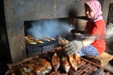 Pekerja melakukan pengasapan ikan mujaer di Desa Penatarsewu, Tanggulangin, Sidoarjo, Jawa Timur, Senin (26/3). Warga di kampung tersebut sekitar 50 persen industri rumahan yang menggantungkan hidup dengan mengolah aneka ikan mentah air tawar menjadi ikan asap siap saji dengan memproduksi 3000 ekor yang dipasarkan seharga Rp 45.000 perkilogram. Antara Jatim/Umarul Faruq/zk/18