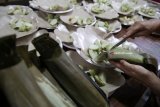 Warga Tionghoa memotong lontong untuk disajikan ke dalam piring di Kelenteng Tjoe Hwie Kiong di Kota Kediri, Jawa Timur, Jumat (2/3). Sebanyak 1000 lontong disajikan untuk dimakan bersama saat merayakan Cap Go Meh sebagai rangkaian penutupan perayaan Tahun Baru Imlek. Antara Jatim/Prasetia Fauzani/zk/18