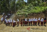 Sejumlah siswa sekolah Madrasah Ibtidaiyah (MI) Pasawahan kerja bakti membantu membangun kelas baru saat jam istirahat di Dusun Ciakar, Kabupaten Ciamis, Jawa Barat, Selasa (6/3). Minimnya biaya pembangunan untuk kelas baru, ditambah tinggnya biaya angkut material bangunan karena letaknya di daerah terpencil, menyebabkan siswa dan orang tua murid bergotong royong membantu membangun sekolah yang kelasnya roboh akibat bencana pergerakan tanah. ANTARA JABAR/Adeng Bustomi/agr/18