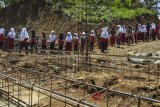 Sejumlah siswa sekolah Madrasah Ibtidaiyah (MI) Pasawahan kerja bakti membantu membangun kelas baru saat jam istirahat di Dusun Ciakar, Kabupaten Ciamis, Jawa Barat, Selasa (6/3). Minimnya biaya pembangunan untuk kelas baru, ditambah tinggnya biaya angkut material bangunan karena letaknya di daerah terpencil, menyebabkan siswa dan orang tua murid bergotong royong membantu membangun sekolah yang kelasnya roboh akibat bencana pergerakan tanah. ANTARA JABAR/Adeng Bustomi/agr/18