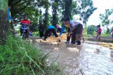 Siswa SDN Kowel 3 bersama guru memperbaiki jalan yang rusak di Kelurahan Kowel, Pamekasan, Jawa Timur, Sabtu (10/3). Jalan yang menjadi akses utama itu rusak parah sejak beberapa tahun lalu dan menghambat aktivitas warga setempat. Antara Jatim/Saiful Bahri/zk/18