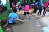 Siswa SDN Kowel 3 terpeleset (kiri) saat memperbaiki jalan yang rusak di Kelurahan Kowel, Pamekasan, Jawa Timur, Sabtu (10/3). Jalan yang menjadi akses utama itu rusak parah sejak beberapa tahun lalu dan menghambat aktivitas warga setempat. Antara Jatim/Saiful Bahri/18

