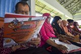 Penyandang tunanetra membaca brosur petunjuk pemilihan pada Sosialisasi Pilgub Jabar kepada kelompok Disabilitas di RM Baraya Sunda, Kota Tasikmalaya, Jawa Barat, Selasa (13/3). Sosialisasi dan simulasi tersebut untuk memberikan pengetahuan kepada penyandang disabilitas dalam menyalurkan hak suaranya pada tahapan Pilgub Jawa Barat yang akan dilaksanakan 27 Juni 2018 mendatang. ANTARA JABAR/Adeng Bustomi/agr/18.