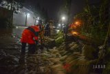 Petugas pemadam kebakaran dibantu oleh warga memperbaiki tanggul Sungai Cikileuy yang jebol di Arcamanik, Bandung, Jawa Barat, Kamis (8/3) malam. Tanggul tersebut jebol akibat intensitas hujan yang tinggi di beberapa wilayah Kota Bandung sejak siang hingga malam hari. ANTARA JABAR/Raisan Al Farisi/agr/18