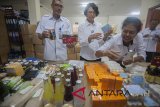 Petugas Balai Besar Pengawas Obat dan Makanan (BBPOM) Denpasar memeriksa berbagai obat berbahaya, makanan dan minuman tanpa izin edar di sela konferensi pers hasil temuan BBPOM di Denpasar, Bali, Rabu (28/3). BBPOM Denpasar yang menggelar inspeksi di tiga kabupaten di Bali, menyita ratusan kemasan obat/kosmetika mengandung bahan berbahaya, makanan/minuman impor tanpa izin edar yang banyak dijual di sejumlah kawasan wisata. Antaranews Bali/Nyoman Budhiana/2018.