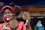 Perajin menunjukkan hasil kerajinan berbahan limbah kertas koran saat digelar ‘The Spoor Festival’ di halaman Pasar Spoor Kota Madiun, Jawa Timur, Selasa (6/3). Kegiatan pameran yang digelar PT Industri Kereta Api (Inka) Madiun dengan melibatkan puluhan Usaha Mikro Kecil Menengah (UMKM) mitra PT Inka tersebut dimaksudkan untuk membangkitkan perekonomian di daerah lewat UMKM. Antara Jatim/Foto/Siswowidodo/zk/18