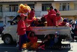 Beberapa pendukung tim barongsai dan naga tampak beristirahat sambil menunggu giliran beratraksi memainkan  naga dan barongsai dalam perayaan Cap Go Meh 2018 di Kota Pontianak (Foto Antaranews / Nurul Hayat)