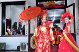 Dua model remaja menampilkan pakaian bertema oriental pada Youth Creative Festival Cap Go Meh di kawasan Cagar Budaya Kampung Kapitan Palembang, Sumsel, Rabu (28/2). Festival yang diisi kaum muda ini untuk mengenalkan keberagaman dan budaya Tiongkok yang berakulturasi dengan budaya setempat. 