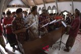 Umat Katolik mengikuti prosesi Misa Jumat Agung di Gereja Katolik Paroki Roh Kudus Babakan, Badung, Bali, Jumat (30/3). Peringatan Jumat Agung di gereja tersebut diikuti oleh jemaat yang mengenakan pakaian adat Bali. ANTARA FOTO/Fikri Yusuf/wdy/2018.