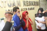 Petugas kepolisian Polres Aceh Barat menunjukkan pasangan suami istri dengan inisial H dan E yang bertindak sebagai mucikari dalam bisnis prostitusi dan eksploitasi anak di bawah umur saat gelar perkara di Mapolres Aceh Barat, Aceh, Senin (19/3). Polisi berhasil mengungkap bisnis prostitusi yang mempekerjakan anak dibawah umur pada Jumat (16/3), atas perbuatannya kedua pelaku diancam dengan hukuman 10 tahun penjara dan denda Rp200 juta rupiah. (ANTARA FOTO/Syifa Yulinnas/aww/18)