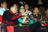 Menteri Keuangan Sri Mulyani Indrawati (tengah) didampingi Kepala Badan Ekonomi Kreatif (Bekraf) Triawan Munaf (kiri) dan Anggota Komisi X DPR RI Anang Hermansyah (kanan) saat menghadiri Konferensi Musik Indonesia (KAMI) yang dipusatkan di Taman Budaya Provinsi Maluku, Ambon, Maluku, Rabu (7/3). Menkeu Sri Mulyani Indrawati menyampaikan materi bertajuk 'Menuju Musik Sebagai Ekonomi Baru Kreatif dan Harmonisasi Dalam Ranah Kebijakan Pemerintah'. KAMI yang berlangsung, 7-9 Maret 2018 tersebut diikuti ratusan peserta yang terdiri dari penyanyi, musisi, pencipta lagu, produser serta pihak-pihak terkait dalam ekosistem musik. ANTARA FOTO/Izaac Mulyawan/wdy/2018.