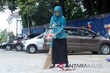 Wakil Ketua I TP PKK Kota Banjarbaru Hj Eny Apriyati Darmawan Jaya menyapu sampah ditengah jalan  Kota Banjarbaru, bersama Ketua TP PKK Kota Banjarbaru Hj Ririen Nadjmi Adhani serta Pengurus TP PKK Kota Banjarbaru. Kegiatan gotong royong kebersihan (babarasih) sampah di sekitar Sekretariat PKK Kota Banjarbaru Jalan Taman Gembira Barat Banjarbaru dalam rangka memperingati Hari Peduli Sampah tahun 2018.Foto Antaranews Kalsel/hms/f) 