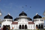 Tiga pesawat tempur Hawk 100/200 melintas di atas Masjid Raya Baiturrahman saat patroli udara di Banda Aceh, Aceh, Jumat (2/3). Sebanyak enam pesawat Hawk 100/200 Skadron Udara 12 Lanud Roesmin Nurjadin, Pekanbaru dikerahkan untuk patroil pengamanan wilayah udara di provinsi Aceh dan latihan tempur menggunakan rudal Maverick. (ANTARA FOTO/Irwansyah Putra/ama/18)