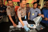 Kapolres Lhokseumawe, AKBP Ari Lasta (tengah), Wakapolres Kompol Imam Asfali (kiri) dan Kasat Reskrim AKP Budi Nasuha Waruwu (kanan) menunjukkan barang bukti senjata api (senpi) bersama tersangka pelaku tindak kejahatan saat dihadirkan di Polres Lhokseumawe, Aceh, Minggu (25/3). Polisi Reserse Mobil (resmob) V berhasil menangkap otak pelaku perampok MA, yang merupakan satu dari lima sindikat perampokan bersenpi yang selama ini beroperasi di jalan Lintas Sumatera (Jalinsum) Medan-Banda Aceh, di tangan pelaku ikut diamankan dua pucuk pistol bersama 15 butir amunisi aktif kaliber 38 mm. (ANTARA FOTO/Rahmad/nz/18)