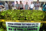 Kapolresta Banda Aceh AKBP Trisno Riyanto SH (tengah) melihat barang bukti tabung gas LPG 3 kilogram subsidi saat rilis kasus di Banda Aceh, Selasa (20/3). Aparat Kepolisian menyita ratusan tabung LPG 3 Kg dan mengamankan dua tersangka karena menjual isi gas Rp35.000 diatas Harga Eceran Tertinggi (HET) yang ditetapkan Pemerintah sebesar Rp18.000/tabung dan tidak memiliki izin dari PT. Pertamina. ANTARA FOTO/Irwansyah Putra.