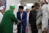 Presiden RI Joko Widodo bersalaman dengan salah satu habib saat tiba di ruang utama mushalla Ar-Raudah Komplek Sekumpul untuk menghadiri Haul ke-13 guru Sekumpul, KH. Muhammad Zaini Abdul Ghani (Guru Izai) Martapura, Minggu, (25/3). Haul dimulai setelah usai salat Maghrib, pembacaan syair-syair Maulid Habsyi dipimpin dua putra almarhum guru Sekumpul Muhammad Amin Badali (23) dan Ahmad Khafi Badali (22) dan tahlilan dipimpin guru Masdar.  Foto: Antaranews Kalsel/humpro /f.