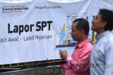 Warga melintas di samping spanduk himbauan pelaporan surat pemberitahuan (SPT) tahunan pajak di KPP Pratama Jakarta Tanah Abang Satu, Jakarta, Senin (19/3). Berdasarkan data Direktorat Jenderal Pajak Kementerian Keuangan hingga Jumat 16 Maret 2018 lalu sebanyak 6,1 juta wajib pajak telah menyampaikan SPT tahunan pajak penghasilan (PPh) 2017. ANTARA FOTO/Sigid Kurniawan/wdy/2018.