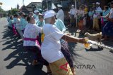 Warga menarik tali dalam rangkaian Tradisi Mbed-Mbedan di Pura Puseh Desa Adat Semate, Kabupaten Badung, Bali, Minggu (18/3). Tradisi unik serupa tarik tambang dengan pakaian adat itu dilakukan setelah melakukan sembahyang usai Hari Raya Nyepi untuk memupuk persaudaraan sekaligus mohon keselamatan dan anugerah dari Tuhan. ANTARA FOTO/Wira Suryantala/wdy/2018.