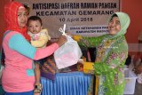 Kepala Dinas Ketahanan Pangan Kabupaten Madiun, Lilin Syarifah Aniesah (kanan) memberikan paket bantuan gizi kepada warga pada kegiatan Antisipasi Daerah Rawan Pangan di Desa Batok, Kecamatan Gemarang, Kabupaten Madiun, Jawa Timur, Selasa (10/4). Pada 2018 Pemkab Madiun mengalokasikan dana antisipasi daerah rawan pangan sebesar Rp75 juta untuk 250 anak di lima kecamatan. Antara Jatim/Foto/Siswowidodo/zk/18