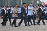 Presiden Joko Widodo (keempat kiri) didampingi Kapolri Jenderal Pol Tito Karnavian (ketiga kiri) dan Panglima TNI Marsekal TNI Hadi Tjahjanto (kedua kanan) mendapat pengawalan dari personil wanita Paspampres usai Apel Bersama Memperingati Hari Kartini Tahun 2018 di Lapangan Silang Monas, Jakarta, Rabu (25/4/2018). Apel tersebut diikuti sekitar 10 ribu peserta dari Korps Wanita TNI, Polwan, gabungan ASN dari kementerian dan lembaga, Satpol PP, Tagana, Paskibra, Menwa, Pramuka dan perwakilan dari berbagai organisasi wanita. (ANTARA FOTO/Widodo S Jusuf) 