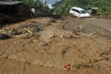 Mobil terjebak material lumpur akibat banjir bandang yang menutupi ruas jalan Sukamakmur-Cianjur di Kampung Cisarua RT 04/05, Desa Sukawangi, Sukamakmur, Kabupaten Bogor, Jawa Barat, Minggu (8/4). Banjir bandang yang terjadi pada Sabtu (7/4) sore tersebut akibat hujan lebat yang melanda wilayah Sukamakmur dan sekitarnya hingga sungai Cisarua meluap dan membanjiri rumah serta kendaraan milik warga serta mengakibatkan satu orang tewas terseret arus banjir. ANTARA JABAR/Arif Firmansyah/agr/18.
