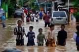 Sejumlah warga keluar rumah menuju tempat pengungsian setelah kampung mereka terendam banjir di Kampung Cibeber, Cilegon, Banten, Rabu (25/4/2018). Banjir terjadi akibat penggundulan hutan secara masif di Bukit Panenjoan hingga Gunung Pinang sehingga air meluap setelah terjadi hujan deras selama dua hari di daerah itu. (ANTARA FOTO/Asep Fathulrahman)