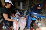 Petugas menimbang sampah yang akan didaur ulang di Bank Sampah Sri Wilis, Kelurahan Pojok, Kota Kediri, Jawa Timur, Sabtu (7/4). Bank sampah swadaya masyarakat itu menerima sampah non organik rata-rata sebanyak 1,8 ton per bulan yang dikumpulkan dari 448 orang nasabah tetap. Antara Jatim/Prasetia Fauzani/zk/18