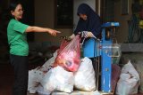 Petugas menimbang sampah yang akan didaur ulang di Bank Sampah Sri Wilis, Kelurahan Pojok, Kota Kediri, Jawa Timur, Sabtu (7/4). Bank sampah swadaya masyarakat itu menerima sampah non organik rata-rata sebanyak 1,8 ton per bulan yang dikumpulkan dari 448 orang nasabah tetap. Antara Jatim/Prasetia Fauzani/zk/18